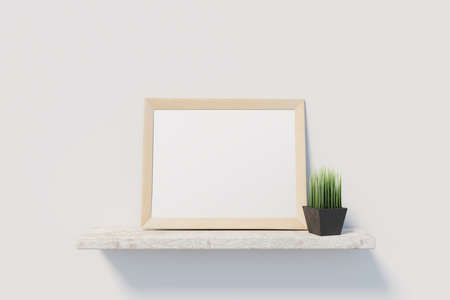 Light wooden picture frame with blank white poster on stone shelve with small black vase with grass on light wall. Mockup. 3D renderingの写真素材