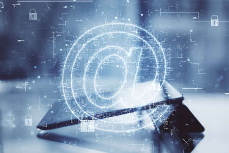 World mail technology with digital glowing email symbol at digital tablet on table background. Double exposureの写真素材