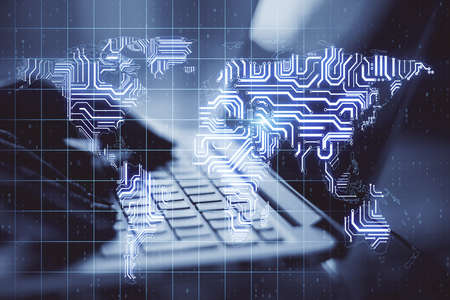 Big data concept with human hand typing on laptop keyboard ans abstract digital microchip world map....