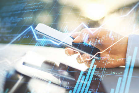 Trading business online with businessman hand using smartphone and digital display with financial...