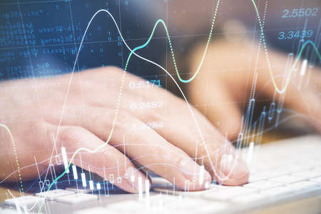 Investment market concept with businessman hands on keyboard and digital financial graphs, candlestick and numbers. Double exposureの写真素材