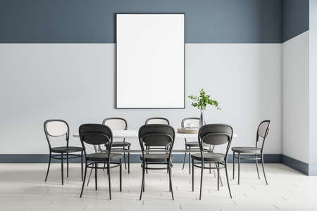 Blank white poster in black frame on the wall in modern room with big dining table with black chairs...