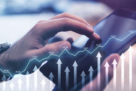Growing stock market concept with financial diagram and arrows up on backdrop with man hand touching...