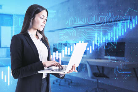 Financial analytic and analysis concept with businesswoman with laptop and digital display of growing financial chart and algorithmic circuitの写真素材