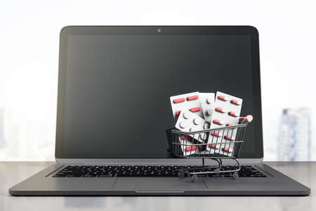 Online pharmacy store business concept with black laptop monitor with copyspace and shopping cart with pills. 3D rendering, mock upの写真素材
