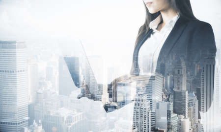 Business concept with businesswoman with laptop on megapolis city background. Double exposureの写真素材