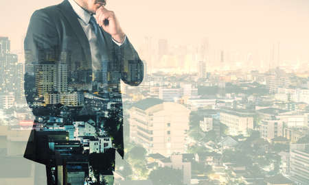 Thinking about future concept with pensive transparent businessman on night city background. Mock up, double exposureの写真素材