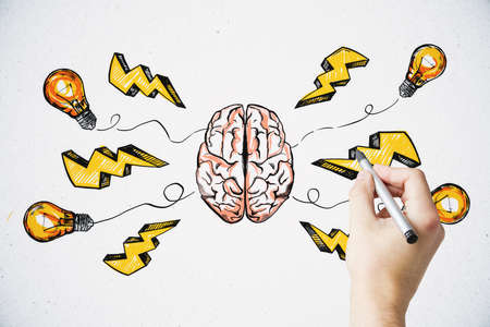 Brainstorming creative idea concept with man hand drawing colorful sketch of human brain parts, yellow lightning strike symbols and light bulbs on the lines on white wallの写真素材