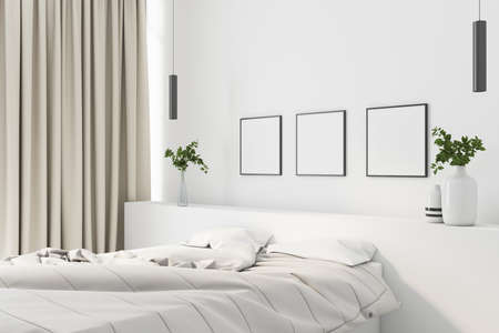 Modern cozy bedroom with white linen and a white wall with three blank posters, flowers in flowerpots and two pillows, 3D Renderingの写真素材