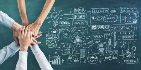 Business plan concept with handwritten sketch of business steps and human hands in sleeves on green chalkboardの写真素材