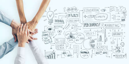 Business plan concept with human hands in a pile and handwritten sketch of business indicators and steps on light surfaceの写真素材