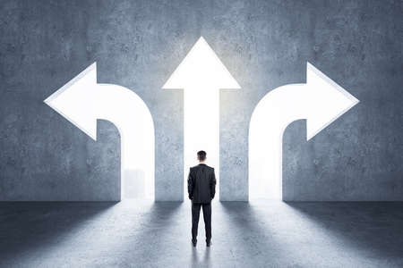 Choice concept with businessman in front of arrow holes directed in different directions in gray...