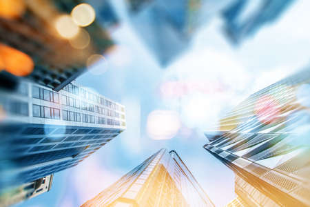 Sunny office buildings from low angle view and bokeh on blue sky background