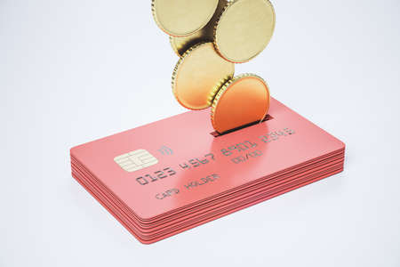 Return money and cash back concept with metal coins bound for a stack of red credit cards on...
