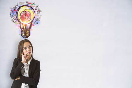 Puzzled businesswoman looking at the brain inside a lightbulb colorful sketch on a white background with empty copyspace in the right, idea and innovation concept, mockupの写真素材