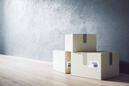 Delivery service and online shopping concept with three cardboard boxes with barcode on wooden floor at blank concrete wall. 3D rendering, mock upの写真素材