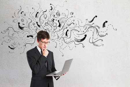 Making decision and choice concept with businessman with laptop on light wall backdrop with black...