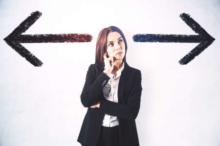 Choice concept with pensive businesswoman between two black arrows on abstract light background