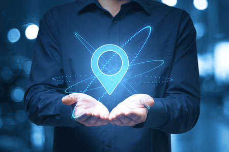Globalization and geo location concept with digital pin point symbol over man open palmsの写真素材