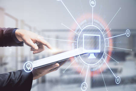 Encircled computer icon with a hand pointing at the tablet in the background, online business and...
