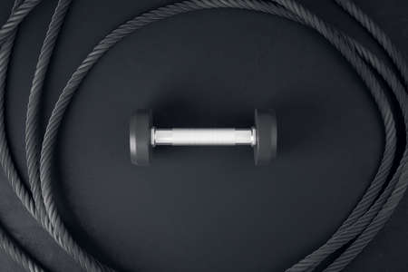 Close up of dumbbell and rope on black background. Sports and fitness equipment concept, 3D...