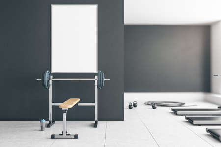 Gray gym interior with empty poster on concrete wall, equipment and daylight. Mock up, 3D Rendering
