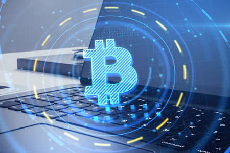 Close up of laptop with round bitcoin interface on blurry desktop background. Cryptocurrency and...