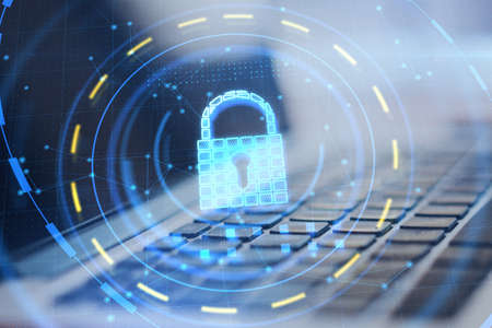 Close up of laptop with glowing padlock hologram on blurry desktop background. Online safety and...