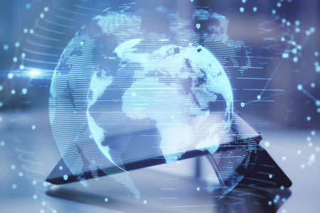 Close up of tablet with abstract globe interface on blurry desktop background. International...