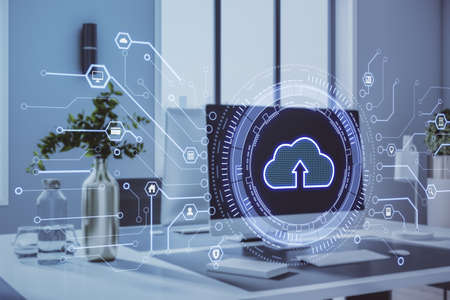 Close up of creative office desktop with glowing cloud interface on burry background. Cloud...