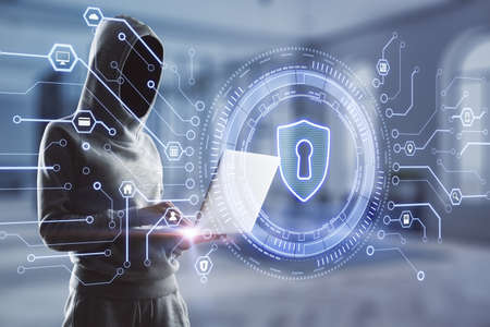 Hacker using laptop with creative glowing lock icon on blurry office interior background. Web safety...
