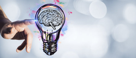 Hand pointing at creative light bulb sketch on blurry bokeh background with mock up place. Idea and...