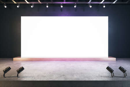 Illuminated empty white billboard in interior with concrete flooring and mock up place for your...