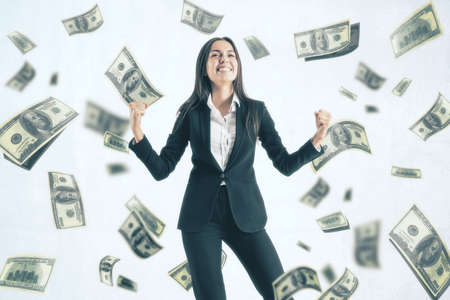 Attractive young european businesswoman celebrating success on white background with dollar banknote...