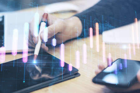 Close up of hands using tablet at desktop with creative glowing business graph and map on blurry...