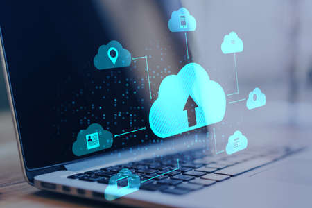 Close up of laptop at desktop with abstract digital cloud on blurry background. Cloud computing,...
