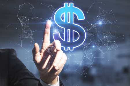 Hand pointing at creative glowing polygonal dollar sign on blurry office interior background. Online banking and digital transformation conceptの写真素材