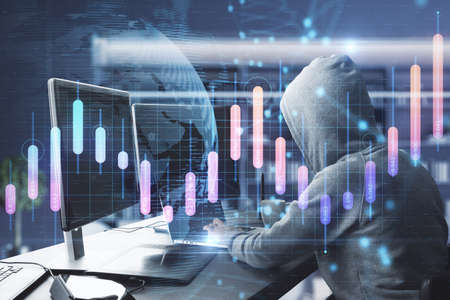 Hacker in hoodie using computer at desktop in blurry office interior with creative glowing business...