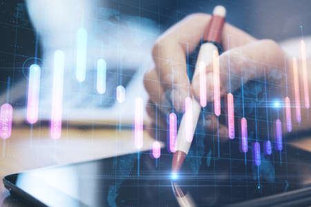 Close up of hands using touchpad at desktop with creative glowing business graph and map on blurry...