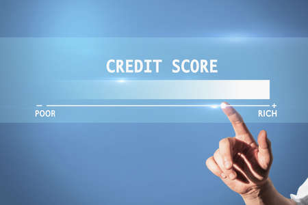 Businessman hand pointing at blue background with credit score scale from poor to rich. Finance and...