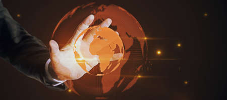 Hand holding glowing globe hologram on dark background with mock up place. Digital interface and global innovationの写真素材