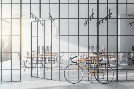 Modern glass partition and bike in stylish coworking office interior with city view and daylight. 3D Renderingの写真素材