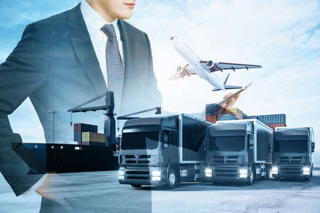 Businessman with pad standing on abstract double exposure background with cargo airplane, truck and ship. Business, shipping, trade and logistics conceptの写真素材