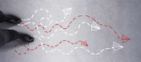 Top view of feet on concrete ground with different arrows. Way, solution, direction and choice conceptの写真素材