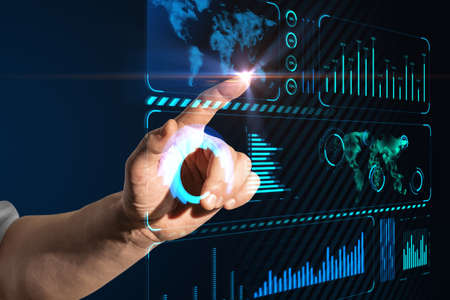 Close up of businessman hand pointing at creative glowing blue business chart hologram with map on...