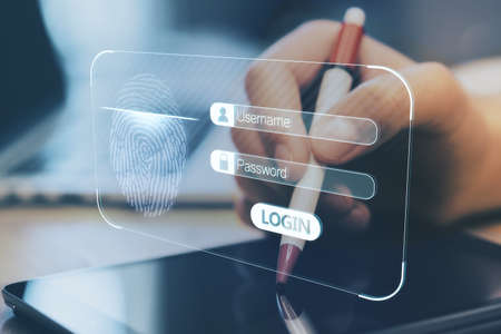 Close up of businessman hand using digital pen on tablet with glowing abstract fingerprint interface on blurry background. Security and information conceptの写真素材