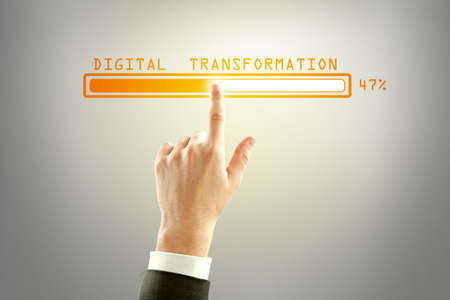 Businessman hand pointing at abstract glowing loading bar on gray wall background. Digital transformation, internet, progress and technology conceptの写真素材