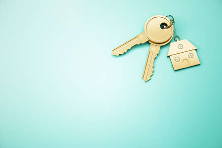 Close up of keys with house keychain on blue surface background with mock up place. Real estate and property concept. 3D Renderingの写真素材