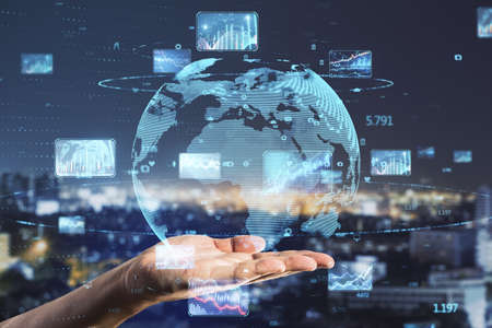 Close up of hand holding abstract globe with forex charts and graphs on blurry night city...