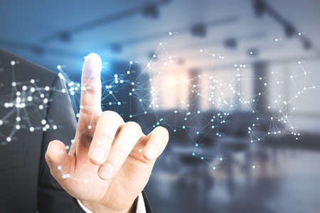 Close up of male hand pointing at glowing polygonal mesh on blurry office interior background....